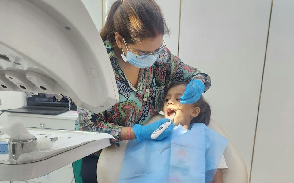 Diş koltuğunda muayene edilen çocuk